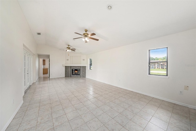 31645 Bugle Ln, Wesley Chapel, FL 33543 - unfurnished living room with ceiling fan, light tile patterned flooring, a tile fireplace, and lofted ceiling