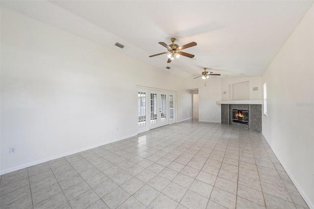 31645 Bugle Ln, Wesley Chapel, FL 33543 - unfurnished living room featuring french doors, a fireplace, a ceiling fan, light tile patterned flooring, and vaulted ceiling