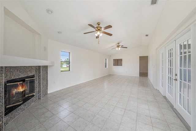 31645 Bugle Ln, Wesley Chapel, FL 33543 - unfurnished living room featuring vaulted ceiling, french doors, a fireplace, light tile patterned flooring, and a ceiling fan