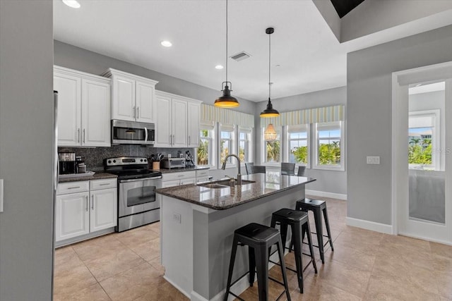 340 Sapphire Lake Dr Unit 202, Bradenton, FL 34209 - kitchen with stainless steel appliances, a sink, white cabinets, decorative backsplash, and recessed lighting
