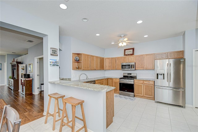 6030 Sandhill Ridge Dr, Lithia, FL 33547 - kitchen with appliances with stainless steel finishes, a peninsula, a sink, ceiling fan, and open shelves