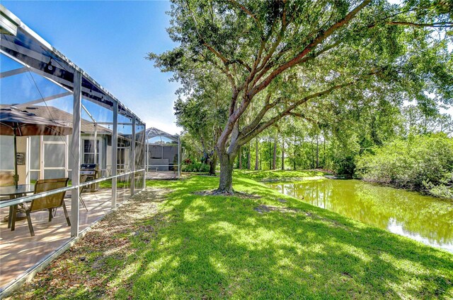 6030 Sandhill Ridge Dr, Lithia, FL 33547 - view of green lawn featuring a water view, a patio, and glass enclosure