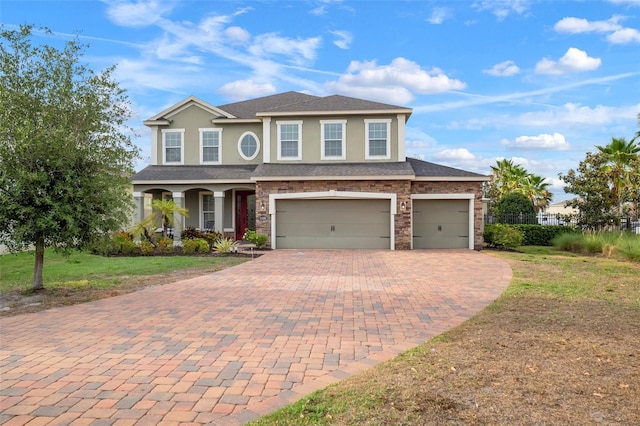 11550 Lake Lucaya Dr, Riverview, FL 33579 - view of front of property with stucco siding, decorative driveway, a front lawn, stone siding, and an attached garage