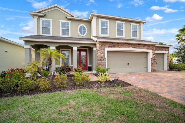 11550 Lake Lucaya Dr, Riverview, FL 33579 - view of front of home with decorative driveway, stone siding, stucco siding, an attached garage, and covered porch