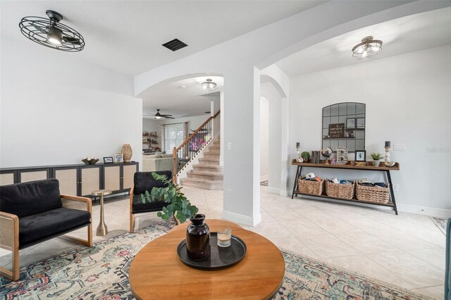 11550 Lake Lucaya Dr, Riverview, FL 33579 - living room with arched walkways, a ceiling fan, light tile patterned flooring, stairs, and baseboards