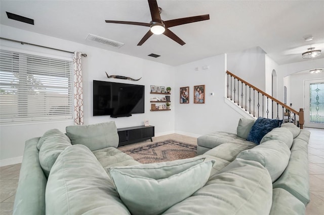 11550 Lake Lucaya Dr, Riverview, FL 33579 - living room featuring arched walkways, ceiling fan, light tile patterned flooring, stairs, and baseboards