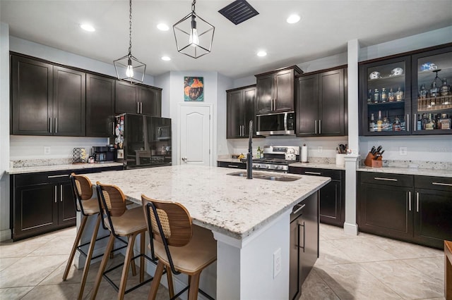 11550 Lake Lucaya Dr, Riverview, FL 33579 - kitchen with stainless steel appliances, light stone counters, an island with sink, hanging light fixtures, and a breakfast bar