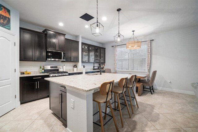 11550 Lake Lucaya Dr, Riverview, FL 33579 - kitchen featuring stainless steel appliances, a sink, a center island with sink, light tile patterned flooring, and recessed lighting