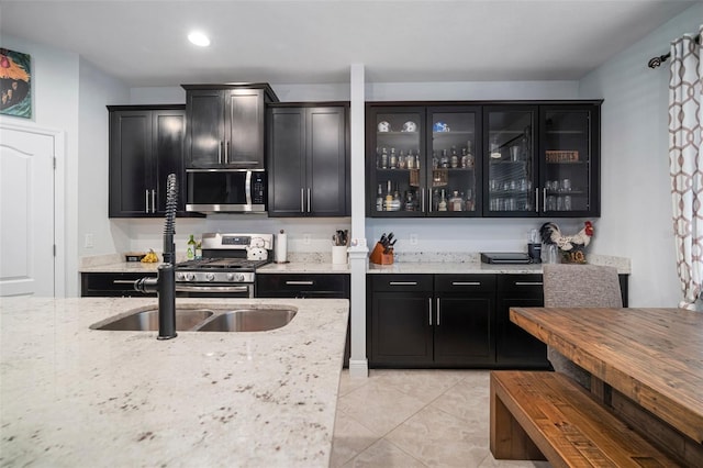 11550 Lake Lucaya Dr, Riverview, FL 33579 - kitchen with stainless steel appliances, dark cabinetry, light tile patterned floors, light stone counters, and recessed lighting