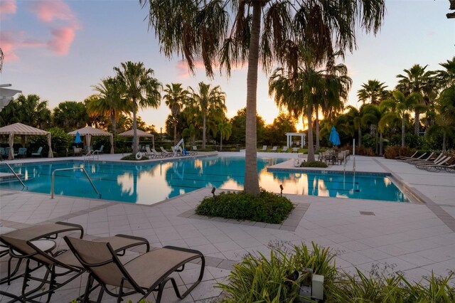 11550 Lake Lucaya Dr, Riverview, FL 33579 - pool at dusk featuring a patio, a community pool, and a gazebo