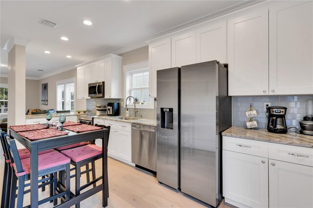 340 6th St E, Bradenton, FL 34208 - kitchen featuring stainless steel appliances, a sink, ornamental molding, recessed lighting, and backsplash