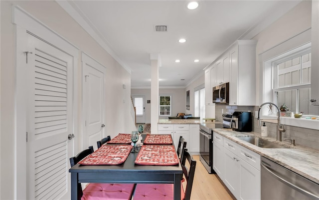 340 6th St E, Bradenton, FL 34208 - kitchen featuring stainless steel appliances, a sink, crown molding, recessed lighting, and light wood-style flooring