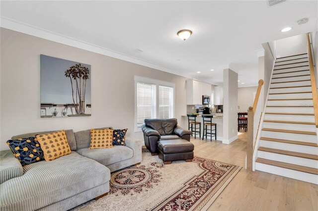 340 6th St E, Bradenton, FL 34208 - living room featuring light wood-style floors, stairs, ornamental molding, and recessed lighting