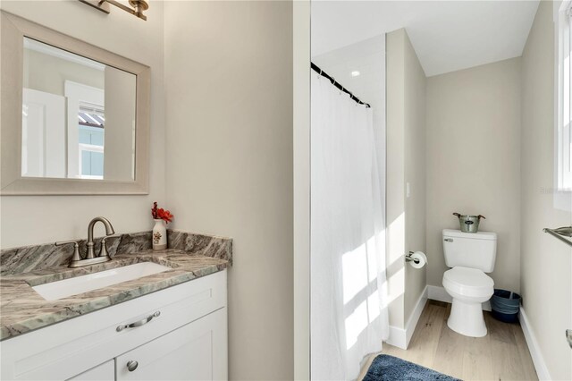 340 6th St E, Bradenton, FL 34208 - bathroom featuring wood finished floors, vanity, toilet, and baseboards