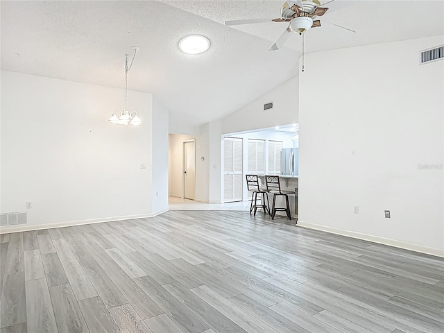 3328 S Whitechappel Pt, Inverness, FL 34452 - spare room with ceiling fan, a chandelier, light wood finished floors, vaulted ceiling, and a textured ceiling