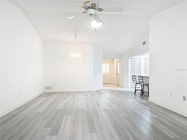 3328 S Whitechappel Pt, Inverness, FL 34452 - unfurnished living room with a ceiling fan, light wood-style flooring, a chandelier, baseboards, and high vaulted ceiling