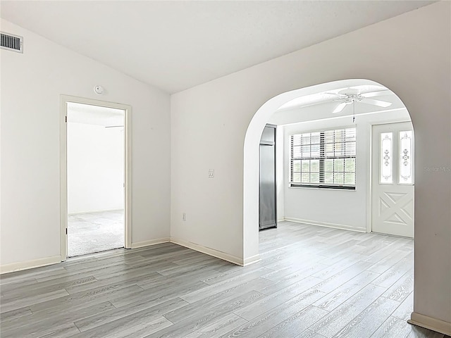3328 S Whitechappel Pt, Inverness, FL 34452 - empty room with arched walkways, light wood-style flooring, a ceiling fan, and baseboards