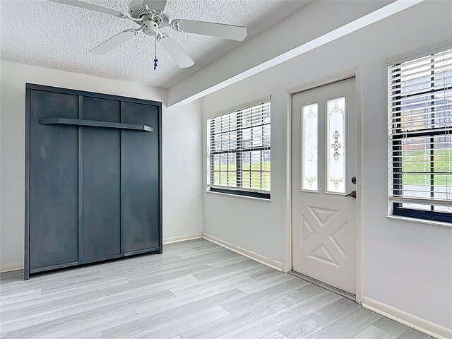 3328 S Whitechappel Pt, Inverness, FL 34452 - foyer featuring a textured ceiling, plenty of natural light, light wood finished floors, a ceiling fan, and baseboards