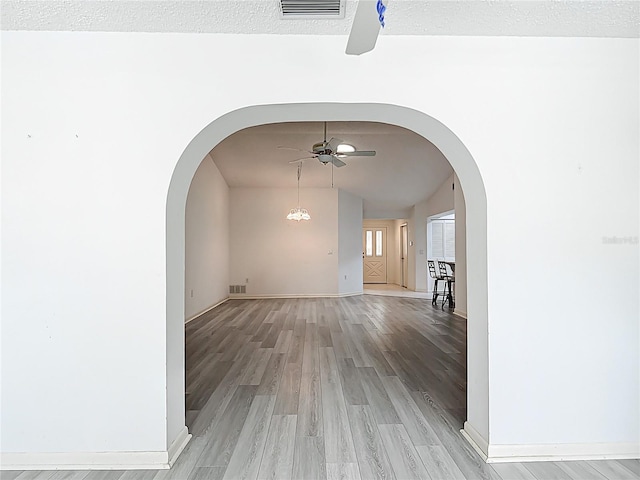 3328 S Whitechappel Pt, Inverness, FL 34452 - hallway featuring lofted ceiling, light wood-style floors, baseboards, and arched walkways
