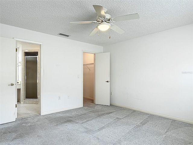 3328 S Whitechappel Pt, Inverness, FL 34452 - unfurnished bedroom featuring carpet floors, a spacious closet, a textured ceiling, a closet, and ensuite bath