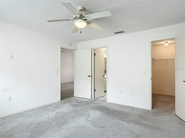 3328 S Whitechappel Pt, Inverness, FL 34452 - unfurnished bedroom with a spacious closet, carpet floors, a textured ceiling, a closet, and ceiling fan