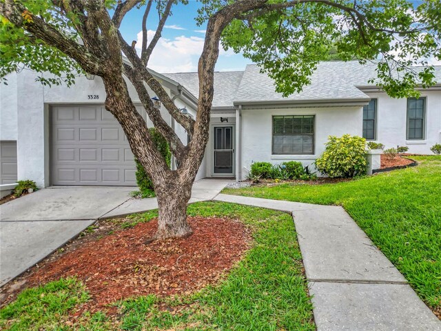 3328 S Whitechappel Pt, Inverness, FL 34452 - view of front of home featuring stucco siding, driveway, roof with shingles, a front lawn, and an attached garage