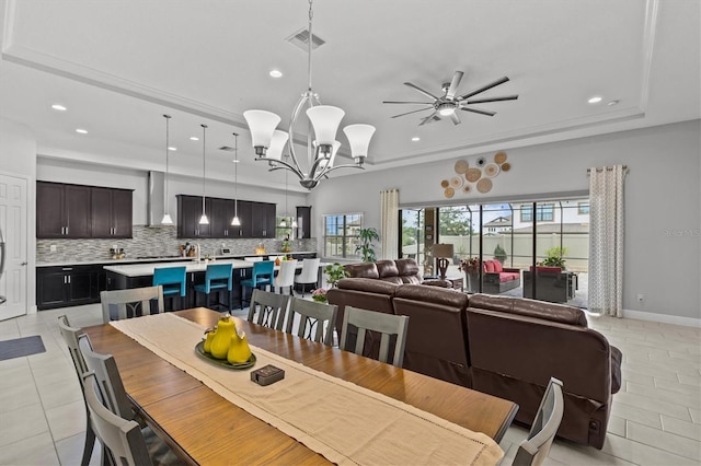 dining room with light tile patterned floors, a chandelier, recessed lighting, ceiling fan, and a tray ceiling