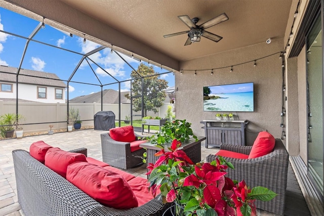 view of patio with outdoor lounge area, fence, a ceiling fan, and a lanai