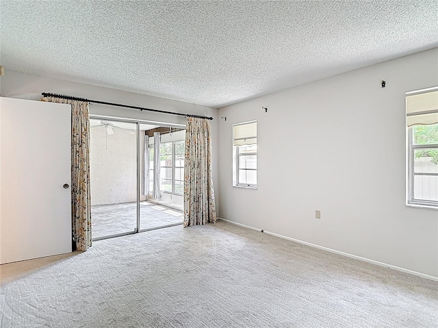spare room featuring a textured ceiling and carpet