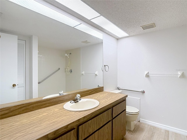 full bathroom with wood finished floors, toilet, baseboards, and vanity