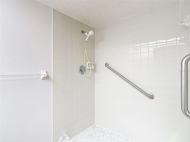 full bath featuring a textured ceiling and a tile shower