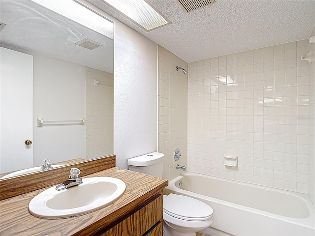 full bath with a textured ceiling, toilet, bathtub / shower combination, and vanity