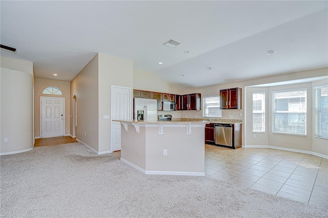 11567 Weston Course Loop, Riverview, FL 33579 - kitchen with appliances with stainless steel finishes, light countertops, a center island, a breakfast bar, and reddish brown cabinets