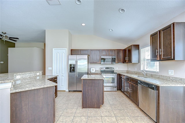 11567 Weston Course Loop, Riverview, FL 33579 - kitchen featuring appliances with stainless steel finishes, a center island, a sink, lofted ceiling, and dark brown cabinets