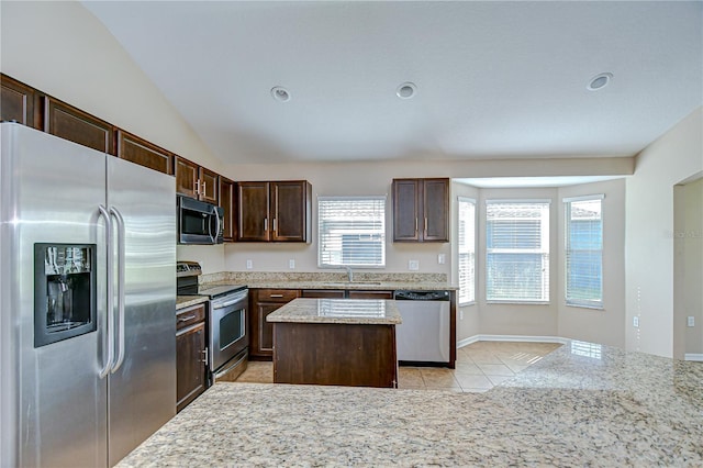 11567 Weston Course Loop, Riverview, FL 33579 - kitchen with appliances with stainless steel finishes, a sink, light tile patterned floors, a kitchen island, and dark brown cabinetry