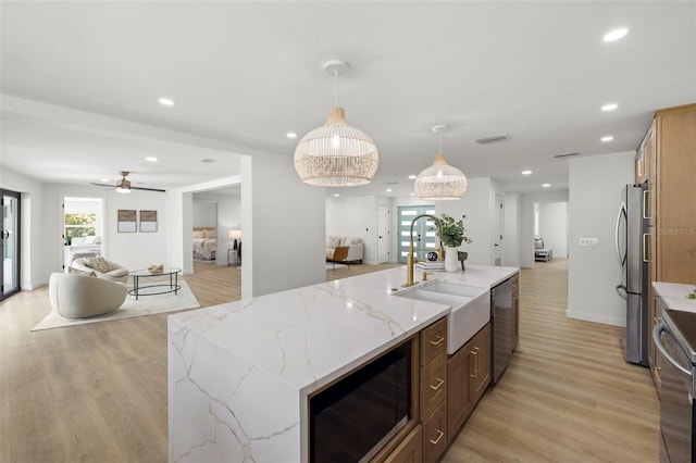 3801 Dr Martin Luther King Jr St N, Saint Petersburg, FL 33703 - kitchen with open floor plan, stainless steel appliances, a sink, light wood finished floors, and a ceiling fan