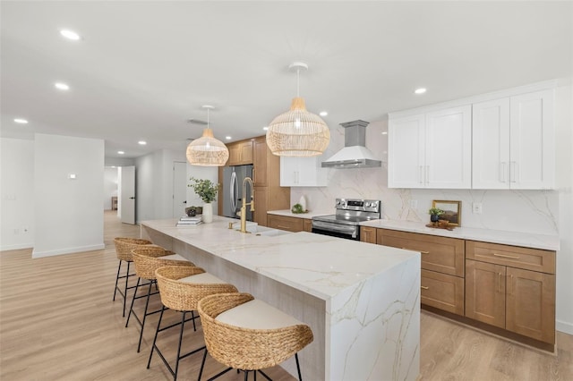 3801 Dr Martin Luther King Jr St N, Saint Petersburg, FL 33703 - kitchen featuring wall chimney range hood, stainless steel appliances, a sink, light wood-style flooring, and decorative backsplash