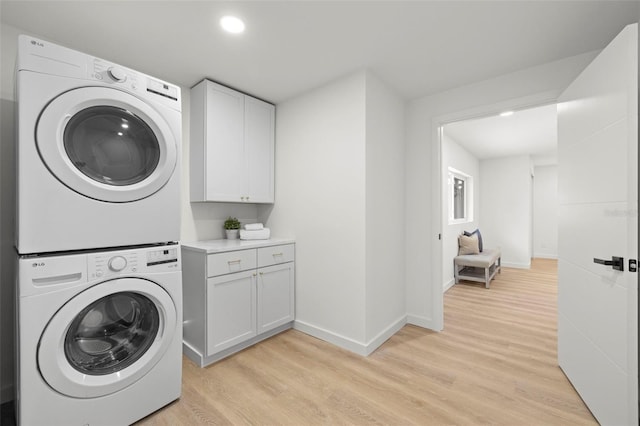 3801 Dr Martin Luther King Jr St N, Saint Petersburg, FL 33703 - laundry room featuring estacked washer and dryer, light wood-type flooring, cabinet space, baseboards, and recessed lighting