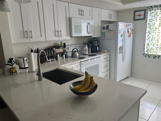 210 Cypress Ct Unit 122, Oldsmar, FL 34677 - kitchen with white appliances, a sink, light stone countertops, light tile patterned floors, and white cabinets