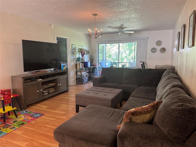 210 Cypress Ct Unit 122, Oldsmar, FL 34677 - living area featuring a textured ceiling, light wood-type flooring, a chandelier, and a ceiling fan