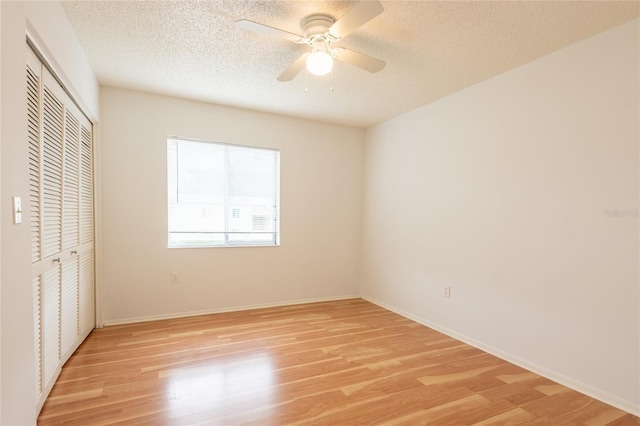 210 Cypress Ct Unit 122, Oldsmar, FL 34677 - unfurnished bedroom featuring a closet, light wood-type flooring, a textured ceiling, and ceiling fan