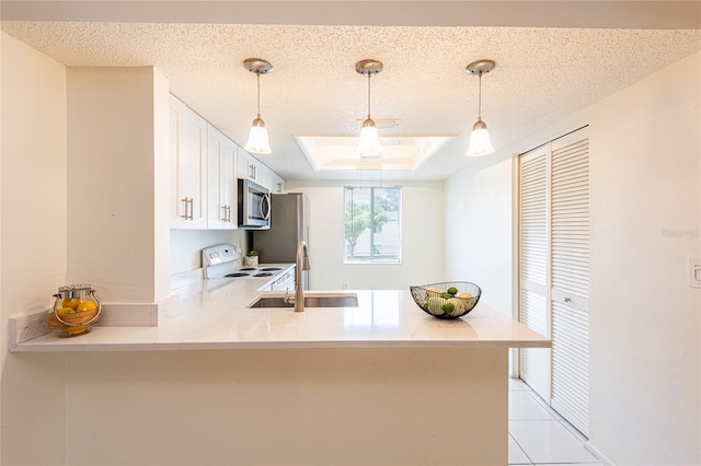 210 Cypress Ct Unit 122, Oldsmar, FL 34677 - kitchen featuring stainless steel appliances, a peninsula, decorative light fixtures, white cabinetry, and a textured ceiling