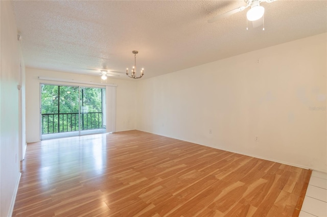 210 Cypress Ct Unit 122, Oldsmar, FL 34677 - empty room featuring a chandelier, light wood-type flooring, a textured ceiling, and a ceiling fan