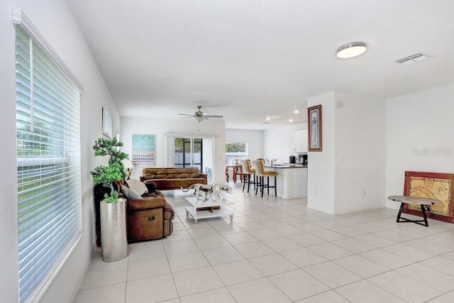 living area featuring light tile patterned floors and ceiling fan