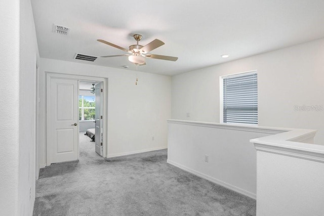 unfurnished room with carpet flooring, ceiling fan, and baseboards