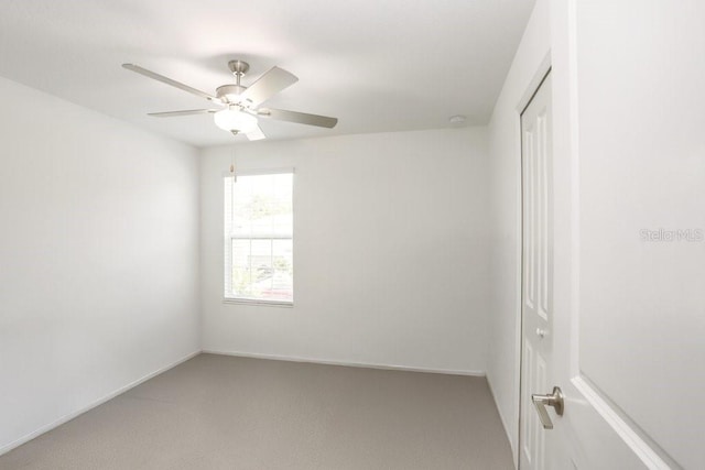empty room with ceiling fan, light carpet, baseboards, and a smoke detector
