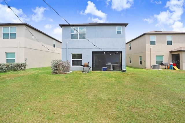 rear view of house featuring stucco siding, a yard, and central AC unit