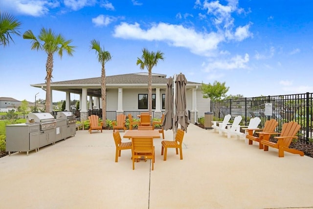 view of patio with fence, area for grilling, and exterior kitchen
