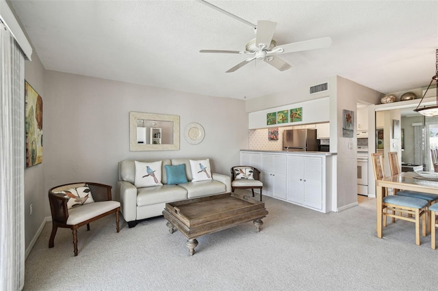 200 1st Ave Unit 406, St Pete Beach, FL 33706 - living area with light colored carpet, ceiling fan, and baseboards
