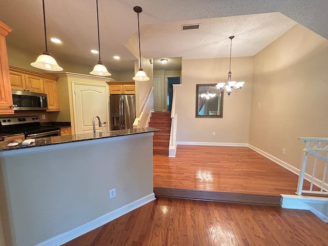 622 Seascape Way, Tampa, FL 33602 - kitchen featuring stainless steel appliances, baseboards, dark stone counters, light wood-style flooring, and recessed lighting